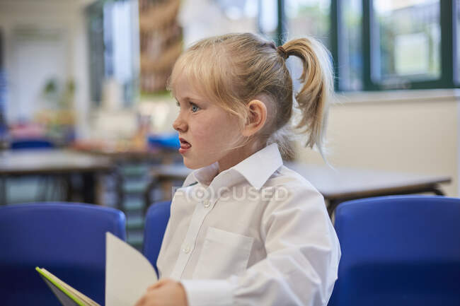 Schoolgirl pulling a face in class at primary school — Stock Photo