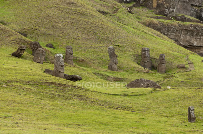 Vista distante de estátuas de pedra em colinas verdes, Ilha de Páscoa, Chile — Fotografia de Stock