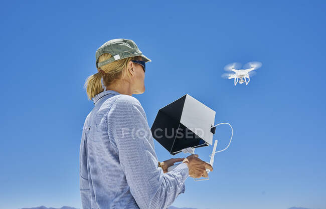Женщина летит дроном, вид с низкого угла, Уюни, Оруро, Боливия, Южная Америка — стоковое фото