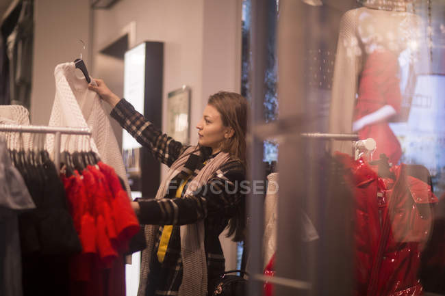 Вид сбоку на молодую женщину в магазине одежды — стоковое фото