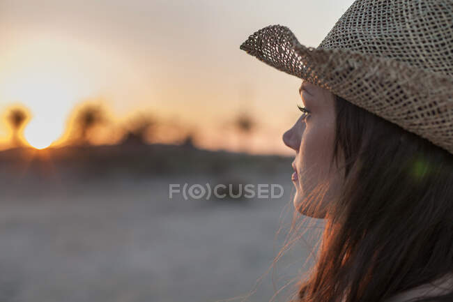 Retrato de mulher usando chapéu de palha olhando para longe — Fotografia de Stock