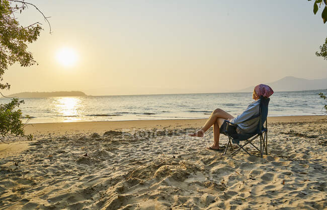 Woman on beach in deckchair looking away at sea, Florianopolis, Santa Catarina, Brazil, South America — Stock Photo