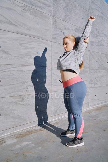 Curvaceous young woman training and stretching arms — Stock Photo