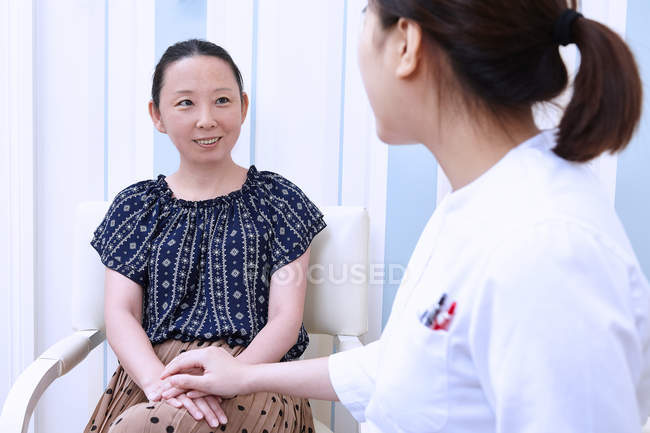 Young female doctor reassuring patient — Stock Photo