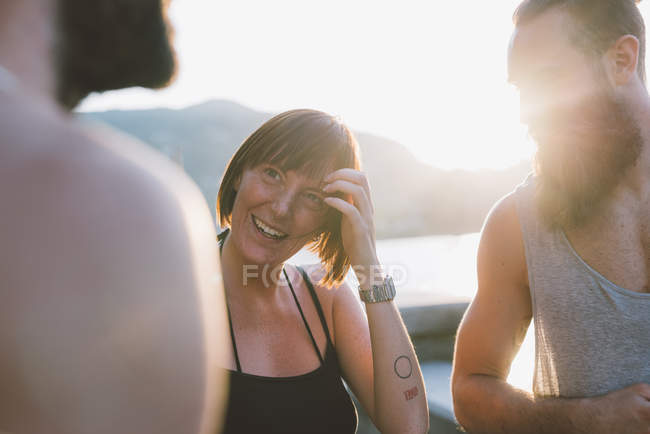Três jovens amigos conversando à beira-mar, Lago de Como, Lombardia, Itália — Fotografia de Stock
