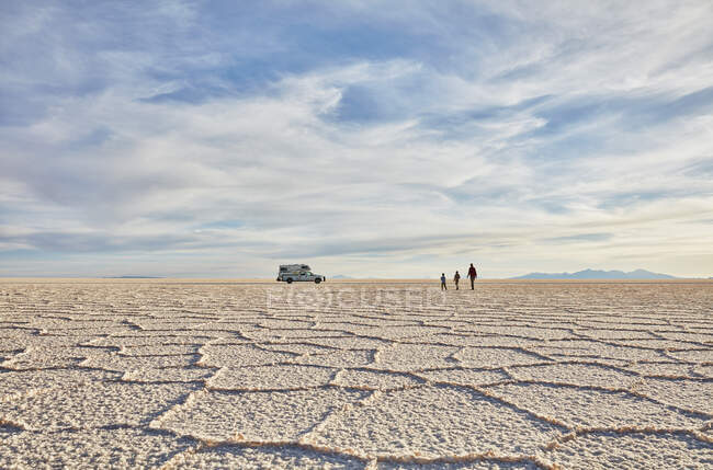 Mutter und Söhne zu Fuß durch die Salinen, Freizeitfahrzeug im Hintergrund, Salar de Uyuni, Uyuni, Oruro, Bolivien, Südamerika — Stockfoto