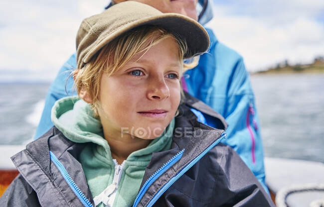 Boy and his mother on motor boat at sea, Puno, Peru — Stock Photo