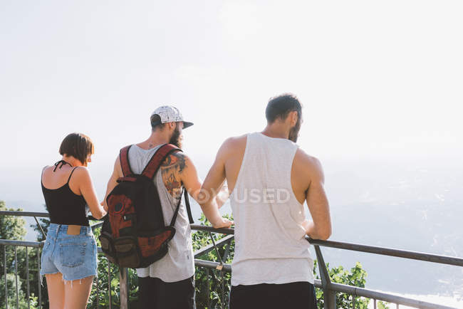 Rear view of friends looking at lake Como from balcony, Como, Lombardy, Italy — Stock Photo