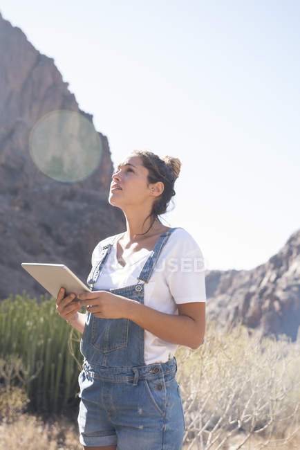 Jeune randonneuse avec tablette numérique dans la vallée ensoleillée, Las Palmas, Îles Canaries, Espagne — Photo de stock