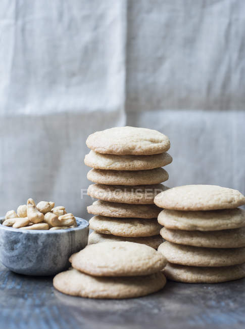 Печенье с орехами кешью в миске на деревянном столе — стоковое фото