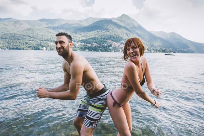 Retrato de pareja en traje de baño nalga a nalga en el Lago de Como, Lombardía, Italia - foto de stock