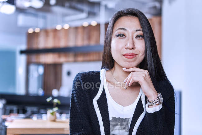Portrait de femme avec la main sur le menton regardant la caméra — Photo de stock