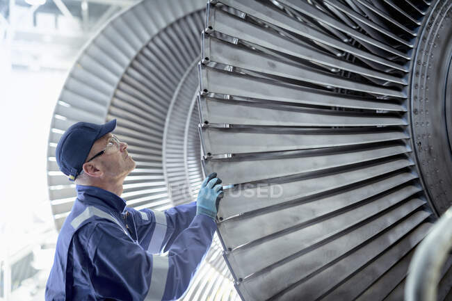 Close up of engineer inspecting low pressure turbine during inspection in turbine maintenance factory — Stock Photo