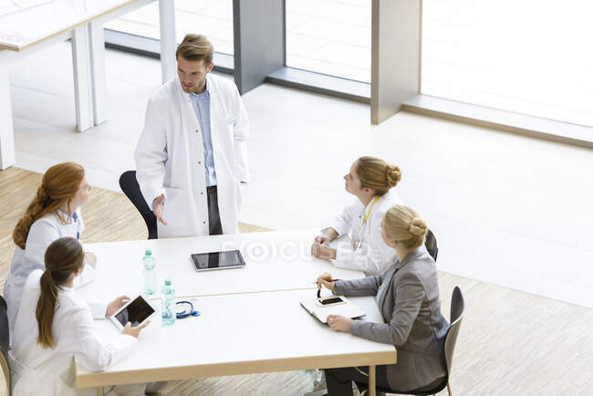 Gruppe von Ärzten, die am Tisch sitzen, Besprechung haben, erhöhte Aussicht — Stockfoto