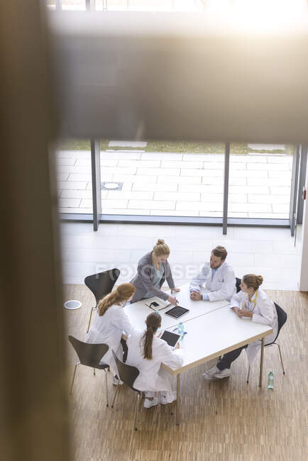Группа врачей, сидящих за столом, имеющих совещание, повышенный вид — стоковое фото