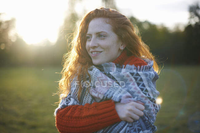 Giovane donna in ambiente rurale, avvolta in una coperta — Foto stock