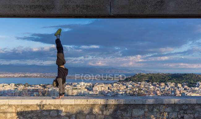 Man doing handstand on wall, Cagliari, Sardenha, Itália — Fotografia de Stock