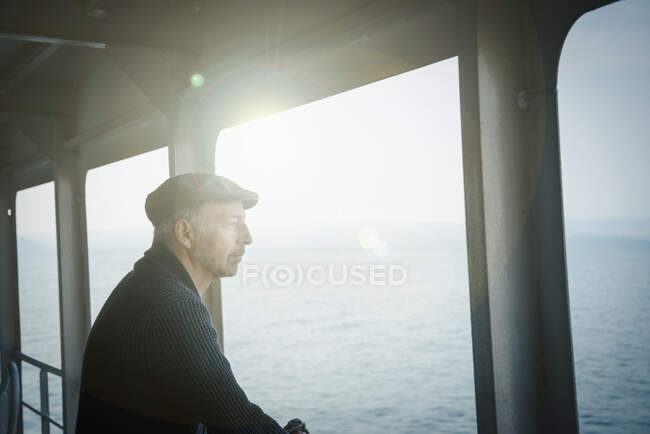 Hombre en ferry mirando por la ventana - foto de stock