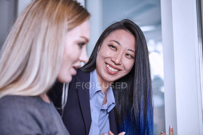 Женщина, глядя на коллегу, улыбается — стоковое фото