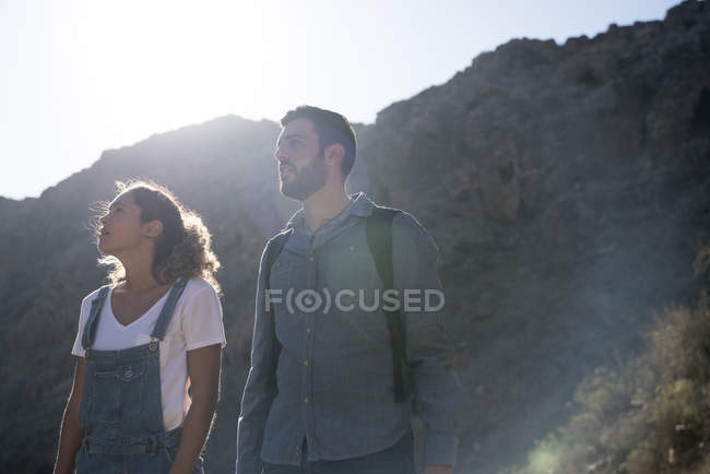 Junges Wanderpaar blickt vom sonnenbeschienenen Tal auf, Las Palmas, Kanarische Inseln, Spanien — Stockfoto