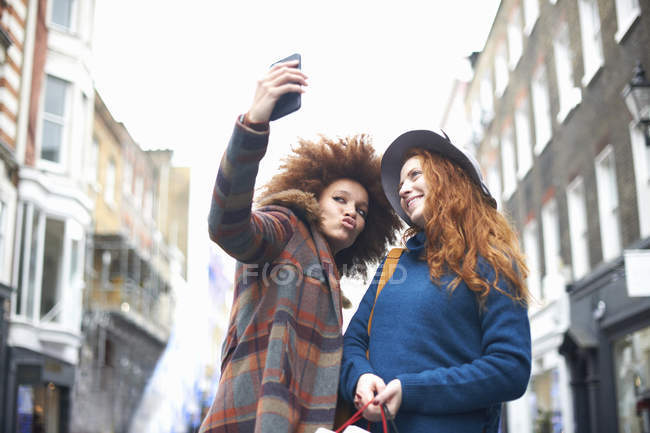 Дві молоді жінки беруть селфі на вулиці — стокове фото