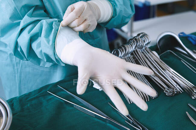 Chirurg zieht OP-Handschuhe im Operationssaal der Entbindungsstation an — Stockfoto