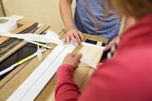 Man and woman in workshop, making ski equipment, mid section — Stock Photo
