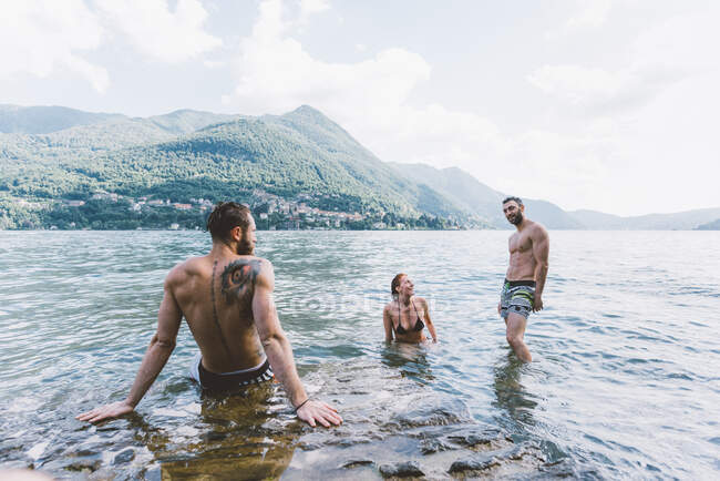 Tres amigos adultos jóvenes en el lago Como, Como, Lombardía, Italia - foto de stock
