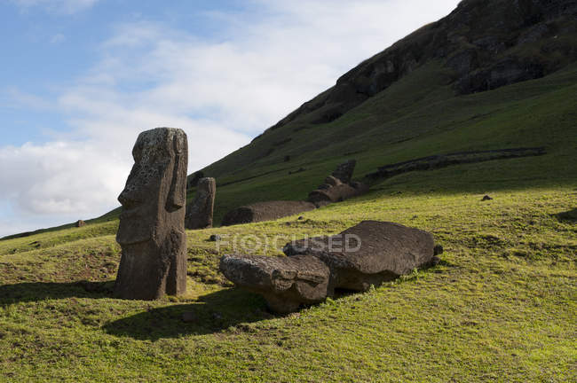 Vista panoramica di statue in pietra immerse nel verde delle colline, Isola di Pasqua, Cile — Foto stock