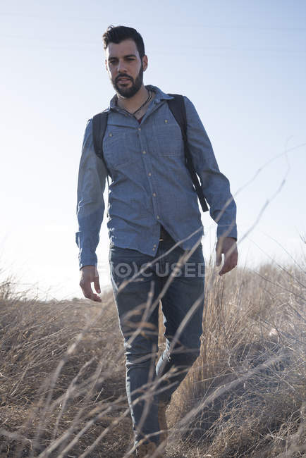 Giovane escursionista di sesso maschile che cammina attraverso l'erba lunga, Las Palmas, Isole Canarie, Spagna — Foto stock