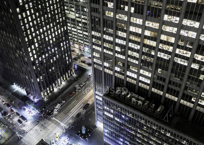 Vista elevada de la calle por la noche, rascacielos en primer plano, Nueva York, Nueva York, Estados Unidos - foto de stock