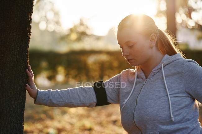 Викривлена молода жінка робить дерев'яний стовбур штовхає згини — стокове фото