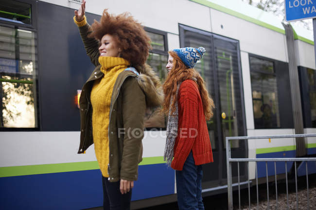 Side view of friends waving at railway carriage — Stock Photo