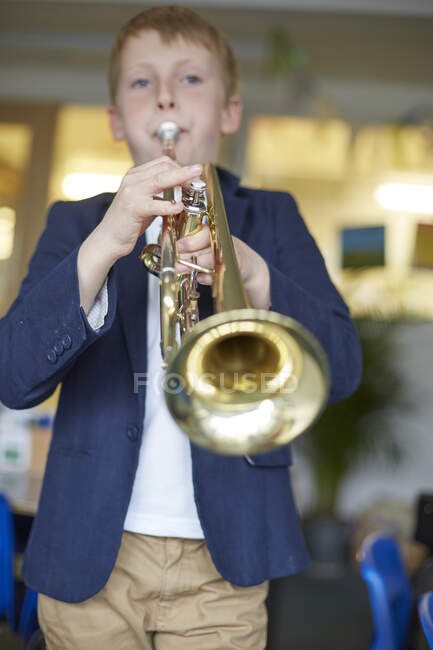 Школярка грає на трубі в початковій школі — стокове фото