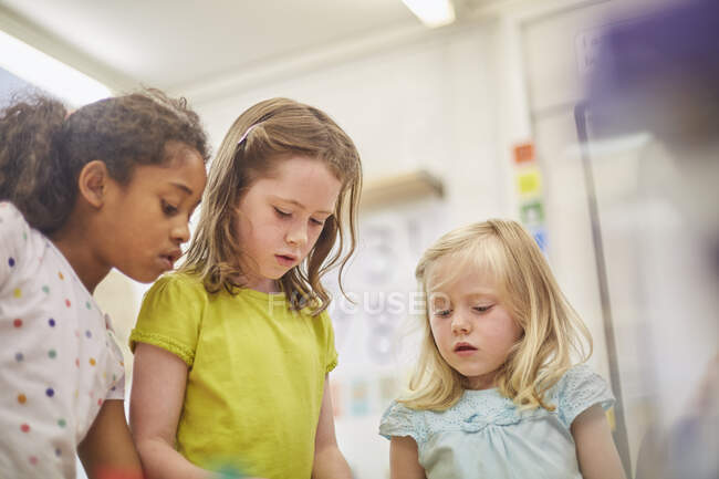 Grundschülerinnen blicken im Klassenzimmer nach unten — Stockfoto