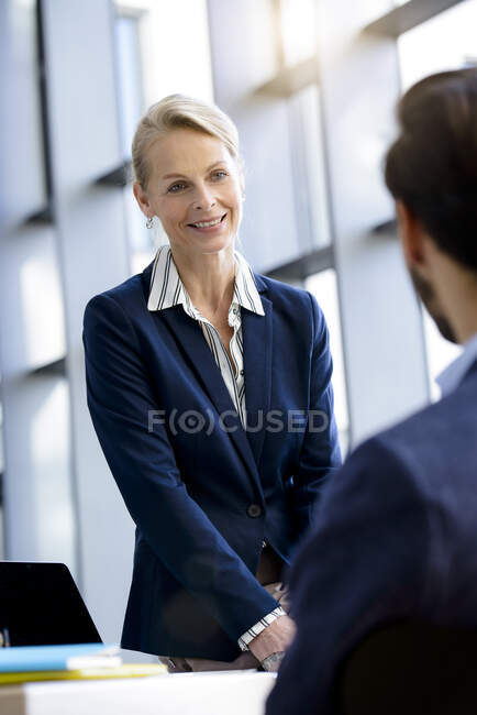 Sobre a vista do ombro da mulher de negócios e do homem que tem a discussão na mesa de escritório — Fotografia de Stock