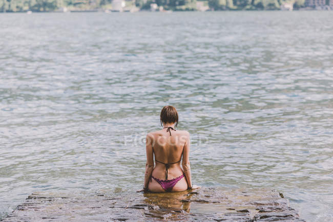 Visão traseira da jovem mulher de biquíni olhando para o Lago de Como, Lombardia, Itália — Fotografia de Stock