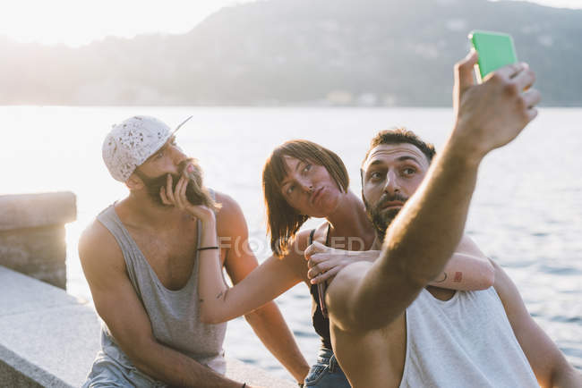 Tre giovani amici che si fanno selfie sul lungomare, Lago di Como, Lombardia, Italia — Foto stock