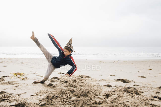 Молодий хлопчик на пляжі практикує бойові мистецтва — стокове фото