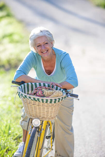 Portrait of senior woman on bicycle — Stock Photo