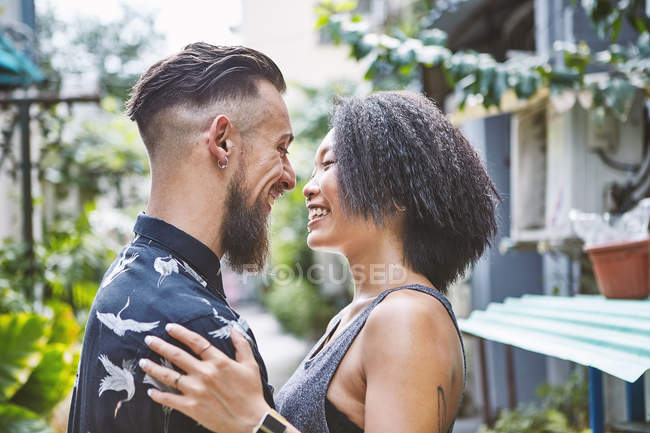 Multi ethnic couple face to face in residential alleyway, Shanghai French Concession, Shanghai, China — Stock Photo