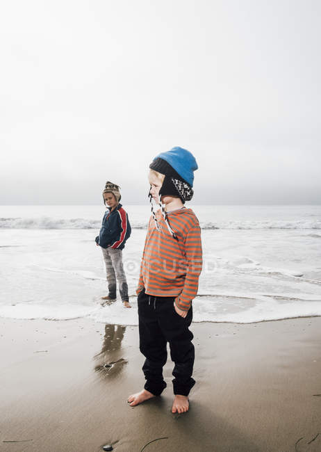 Portrait of two brothers standing on beach — Stock Photo