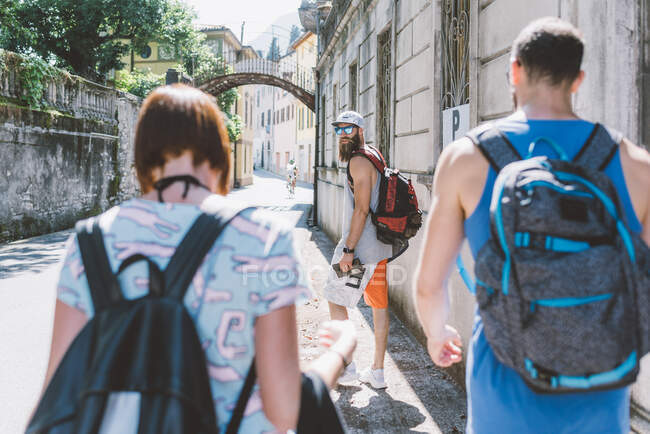 Трое молодых хипстерских друзей прогуливаются по улице, Комо, Ломбардия, Италия — стоковое фото