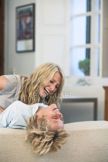 Mother tickling laughing son — Stock Photo