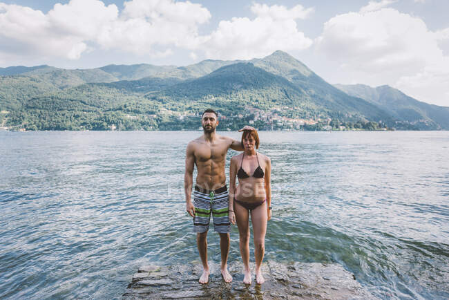 Retrato de casal em roupa de banho em pé na beira da água Lago de Como, Lombardia, Itália — Fotografia de Stock