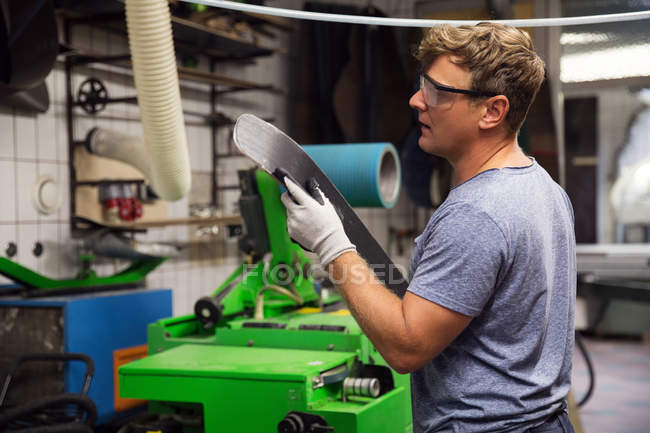 Человек в мастерской по изготовлению лыжного оборудования — стоковое фото