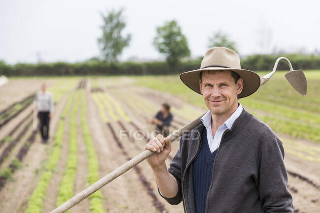 Porträt eines Bauern auf einem Feld mit Hacke — Stockfoto