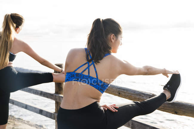 Dos mujeres jóvenes entrenando en el paseo marítimo - foto de stock