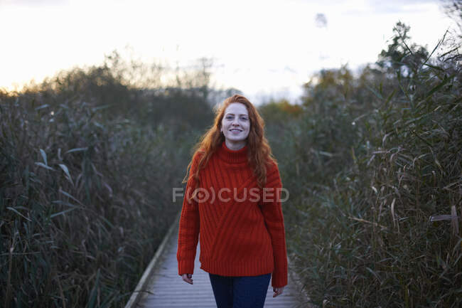 Portrait of young woman walking along rural pathway — Stock Photo