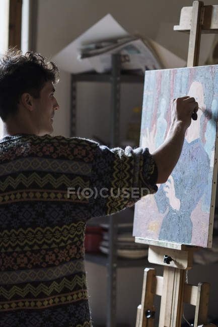 Artist painting on canvas in artist studio — Stock Photo